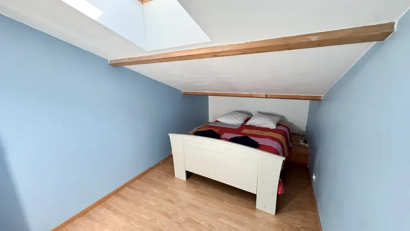 Chambre bleue mansardée avec lit double blanc