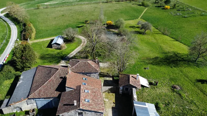Vue aérienne de la maison et du terrain vert qui l'entoure